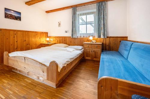 1 dormitorio con 2 camas y sofá azul en Lindenhof Apt 6, en Vandoies