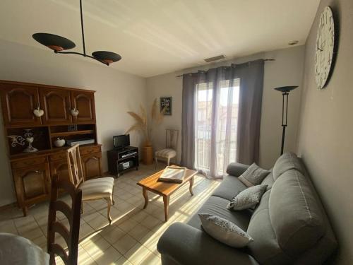 ein Wohnzimmer mit Sofa und Tisch in der Unterkunft Maison Toulouges Climatisée - Proche Perpignan in Toulouges