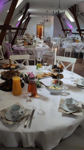 a white table with plates of food on it at Hotel Henriettenhof Weimarer Land, Weimar-Bad Berka in Bad Berka