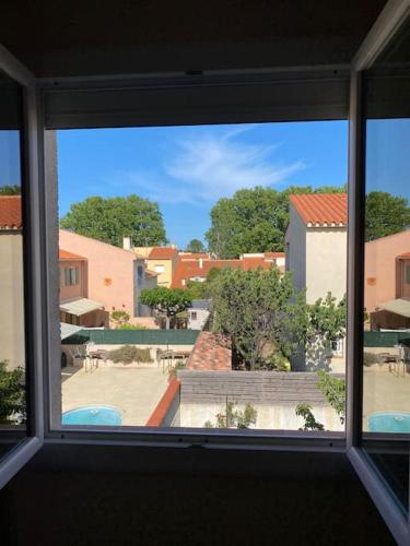 - une fenêtre dans une chambre avec vue sur la cour dans l'établissement Maison Toulouges Climatisée - Proche Perpignan, à Toulouges