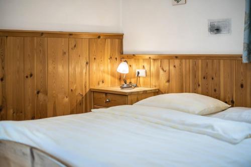 a bedroom with a bed and a table with a lamp at Lindenhof Apt 7 in Vandoies