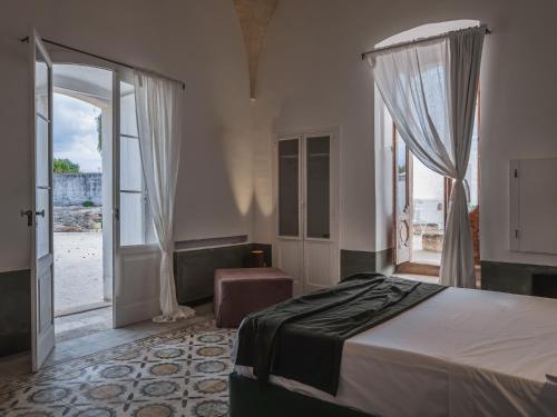 1 dormitorio con 1 cama y puerta abierta en Masseria Monè, en Monopoli