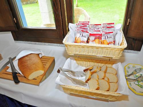 a table with two baskets of bread and breadcuts at Sa Prata Hotel & Resort in Budoni