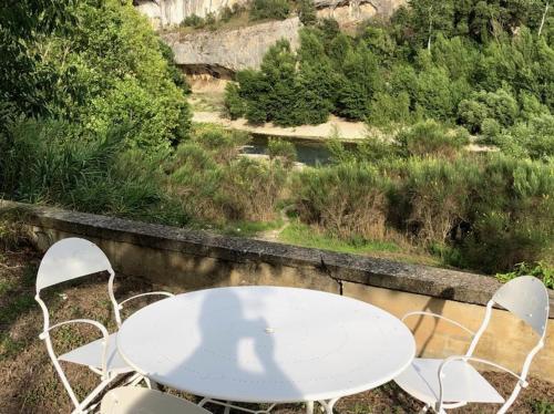 une table et des chaises blanches assises sur un grand livre dans l'établissement LOCATION VACANCES LA VILLA DU GARDON - EXCEPTIONNEL A COLLIAS - ACCES DIRECT A LA RIVIERE - VUE PANORAMIQUE SUR LES GORGES - 2500€/sem, à Collias