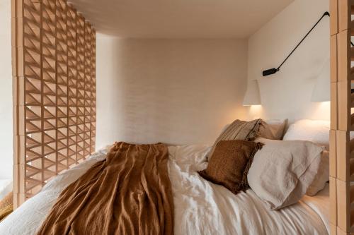 a bedroom with a bed with a wooden headboard at Loft Living Parkview Suite in Nieuwpoort