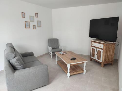a living room with a couch and a tv and a coffee table at Maison au calme avec parking proche centre-ville in Orange