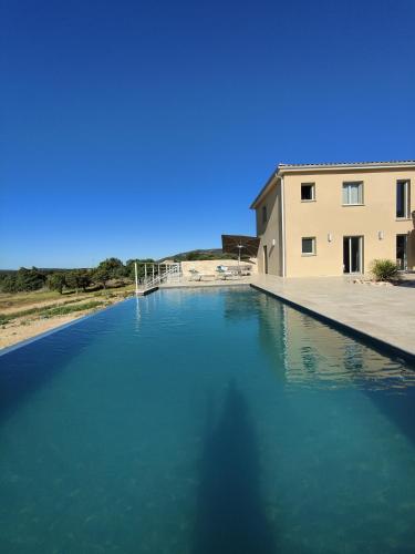 une grande piscine d'eau à côté d'un bâtiment dans l'établissement Casa Amicis, à Gras