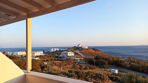 a view of the ocean from the balcony of a house at Aegean Dream Apartments in Tinos Town