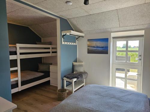 a bedroom with two bunk beds and a window at B&B Hygge Jegindø in Thyholm