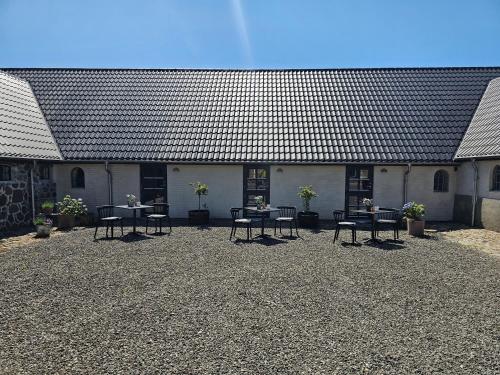 a group of tables and chairs in front of a building at B&B Hygge Jegindø in Thyholm