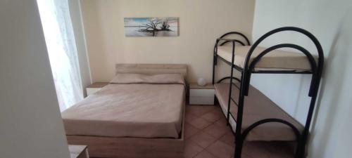 サン・ヴィート・ロ・カーポにあるAppartamento Valentinaの小さな客室で、ベッド1台と二段ベッド1組が備わります。