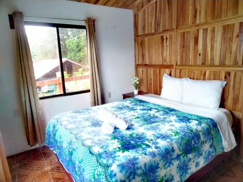 een slaapkamer met een bed en een raam bij Hospedaje Bosque del Río in Monteverde Costa Rica