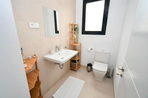 La salle de bains blanche est pourvue d'un lavabo et de toilettes. dans l'établissement Casa Kerr - Luxury Apt - Sleeps 9 - Los Boliches, à Malaga