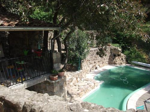 - une piscine avec un mur en pierre à côté dans l'établissement Gîte de la perge haute, à Vals-les-Bains