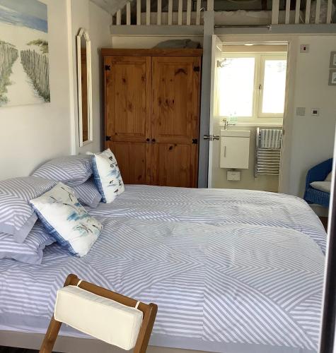 a bedroom with two beds and a chair in it at Ger Tŷ, Reynoldston in Swansea