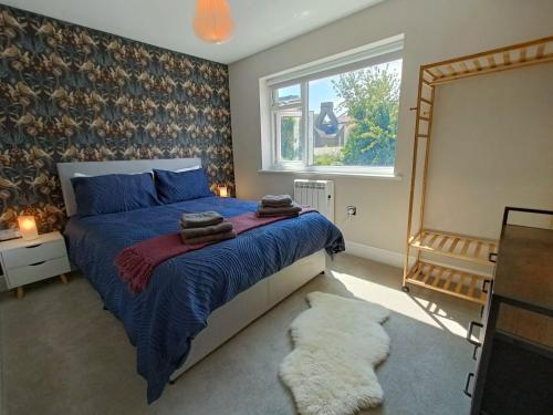 a bedroom with a bed with a blue comforter and a window at Walpole BACK House sleeps 6-8 in Margate