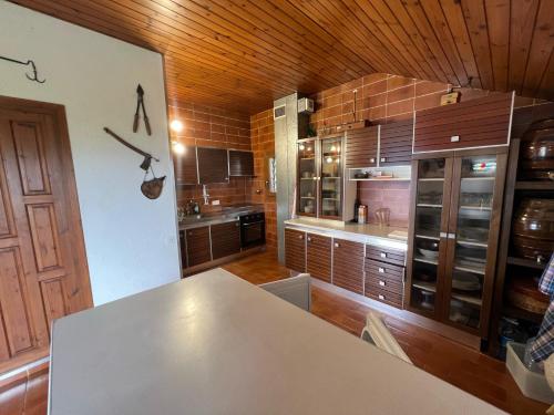 a kitchen with a table and a wooden ceiling at Casa Els Escolls in Lles