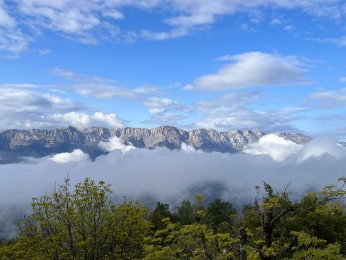 a view of a mountain range with clouds and trees at Casa Els Escolls in Lles
