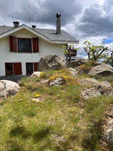 a white house with rocks in front of it at Casa Els Escolls in Lles