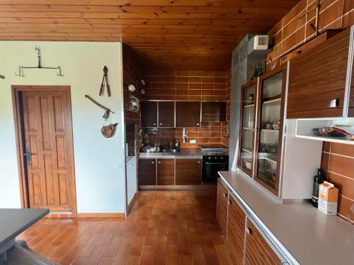 a large kitchen with wooden floors and a door at Casa Els Escolls in Lles