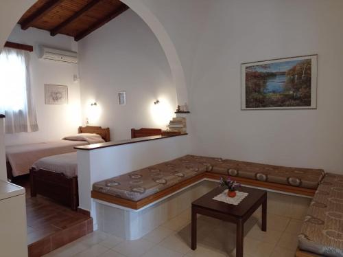 uma sala de estar com um sofá e uma cama em Studios Ioanna Limnionas Samos em Ayía Kiriakí