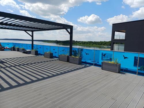 a deck of a building with a view of the water at BOSZKOWO Apartament "EDEL" 106 Aquarius in Boszkowo-Letnisko