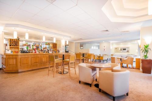 a restaurant with tables and chairs and a bar at Orida Maidstone in Maidstone
