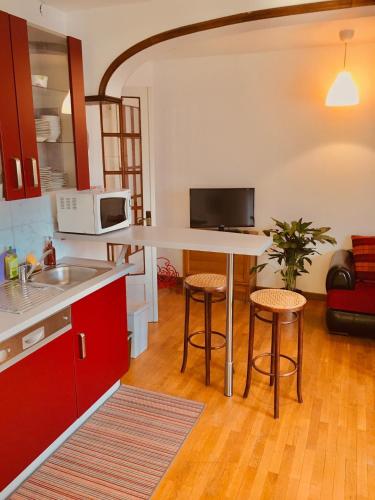 une cuisine avec une table et deux tabourets dans l'établissement Gîte City Relax, entre nature et centre-ville, à Colmar