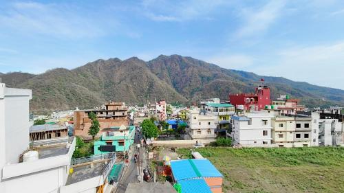 a view of a city with mountains in the background at Athalia guesthouse in Rishīkesh