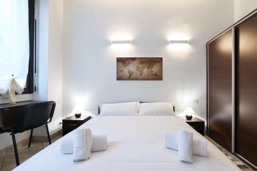 a bedroom with a large white bed and a desk at PrimoPiano - Casoretto in Milan