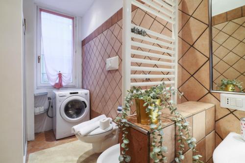 a bathroom with a toilet and a washing machine at PrimoPiano - Casoretto in Milan