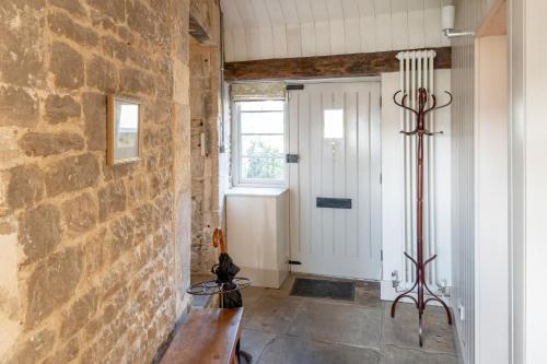 um corredor com uma parede de pedra e uma porta em Shockerwick Cottage em Bath
