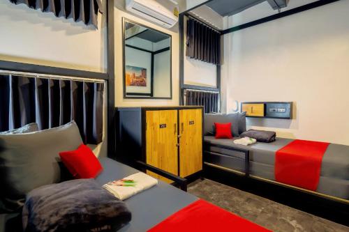 a bedroom with two beds and a mirror at OYO 75456 Episode 11 Hostel Sukhumvit in Bangkok