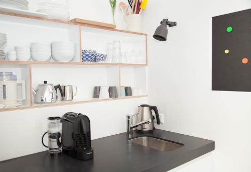 a kitchen counter with a sink and a coffee maker at HiP & STYLISCH B&B in Amsterdam