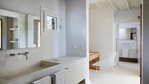 a white bathroom with a sink and a mirror at Home of the Gecko - Mykonos Town in Megali Ammos