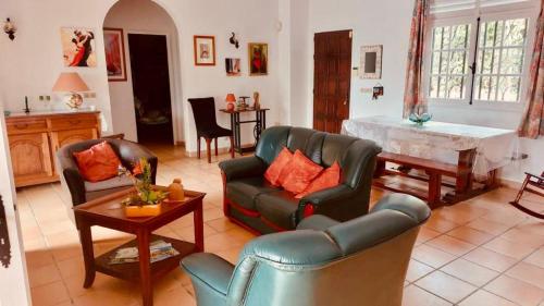 ein Wohnzimmer mit einem Sofa und einem Tisch in der Unterkunft La Bastida : villa avec piscine in Le Moule