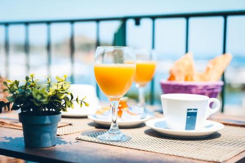 una mesa con dos vasos de zumo de naranja y café en Marina D'oro en Macinaggio