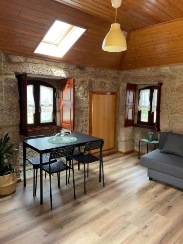 a dining room with a table and chairs and a couch at CASA DA QUELHA in Soajo