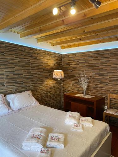 a bedroom with a bed with four pillows on it at CASA DA QUELHA in Soajo