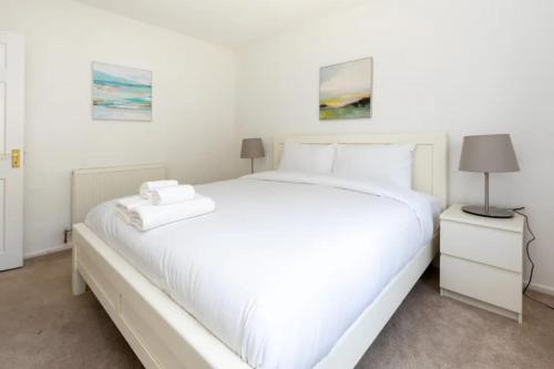 a white bedroom with a large white bed at Spacious & Welcoming 4BD House - Kennington in London