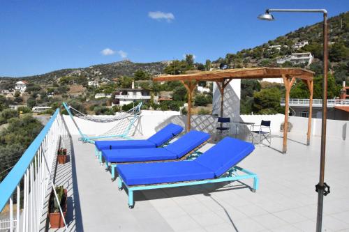 a group of blue lounge chairs on a roof at MNS Marvelous Nirvana Seascape, Creativity in Perani