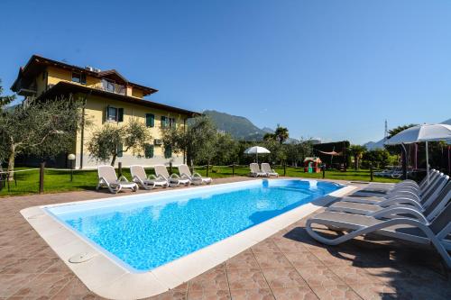 a swimming pool with lounge chairs and a house at Agritur Girasole in Arco