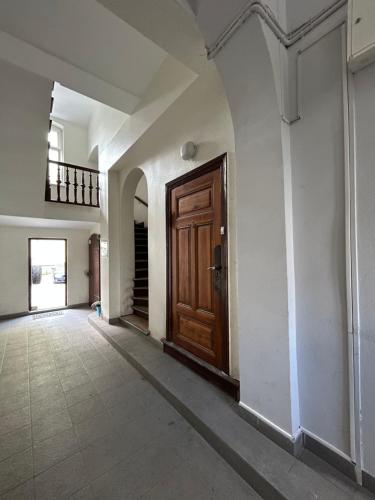 an empty hallway with a wooden door and a staircase at Apartamenty Chrobry in Gorzów Wielkopolski