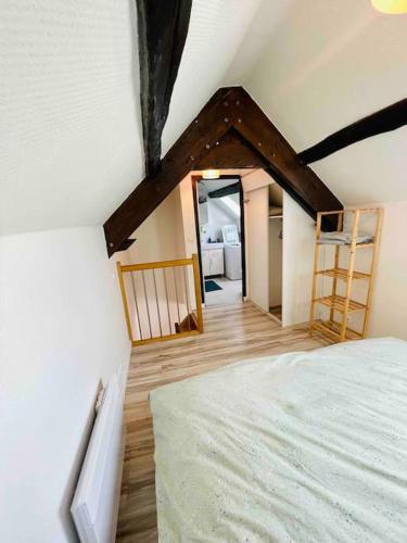 ein Schlafzimmer mit einem Bett in einem Zimmer mit einer Decke in der Unterkunft Maisonnette au cœur de Faremoutiers in Faremoutiers
