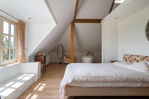 een slaapkamer met een groot bed op zolder bij De Twee Zwanen in Delfstrahuizen