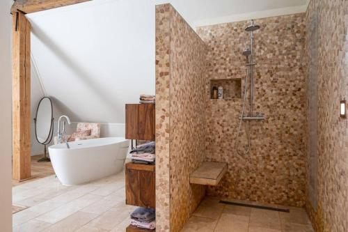 een badkamer met een douche, een bad en een wastafel bij De Twee Zwanen in Delfstrahuizen