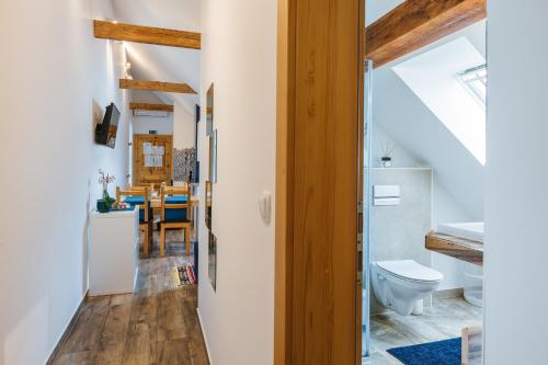 a bathroom with a toilet and a dining room at Pr'Jernejc Agroturism in Lesce