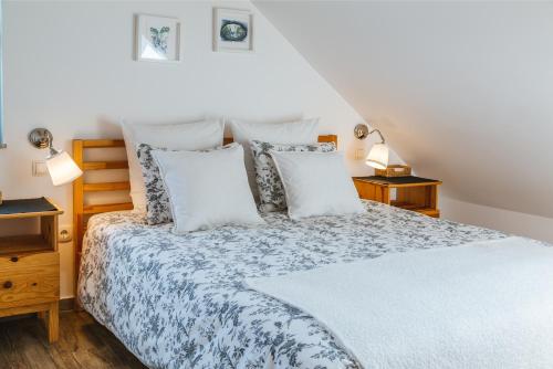 a bedroom with a bed with white sheets and pillows at Pr'Jernejc Agroturism in Lesce