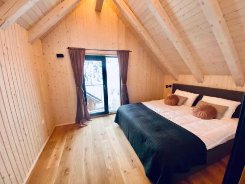 Un dormitorio con una cama grande y una ventana en Čudovita koča na samem, Gorenka, en Cerklje na Gorenjskem