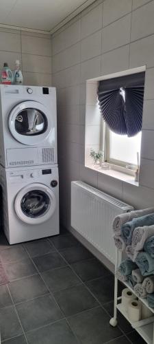 a laundry room with a washing machine and a window at Villa Elme in Växjö